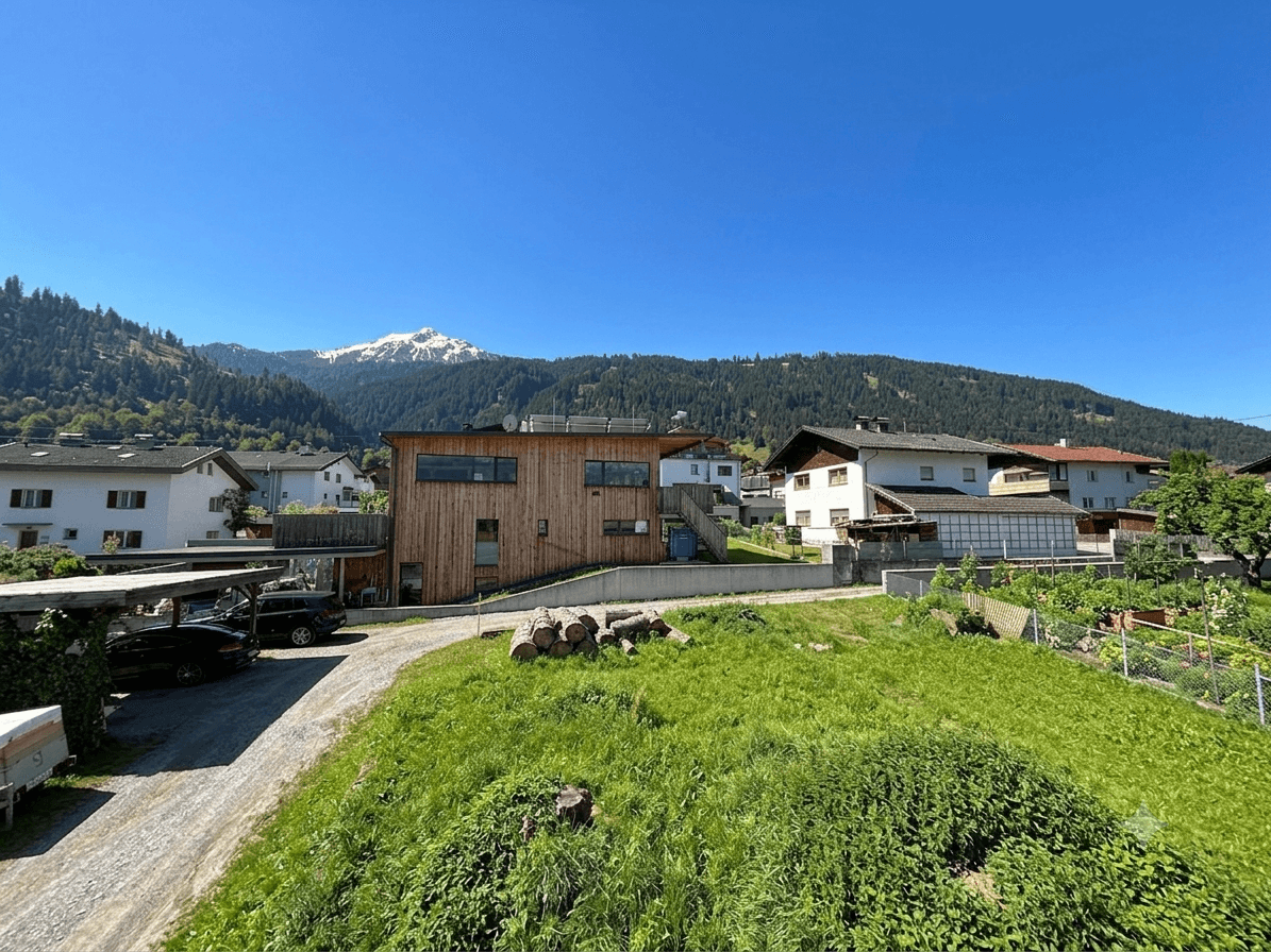 Modernes Holzhaus mit Bergblick und Garten in einer ländlichen Umgebung.