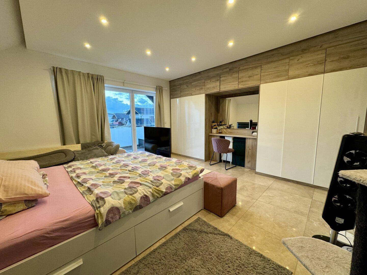 Modernes Schlafzimmer mit Einbauschränken, Fliesenboden und Balkonzugang.