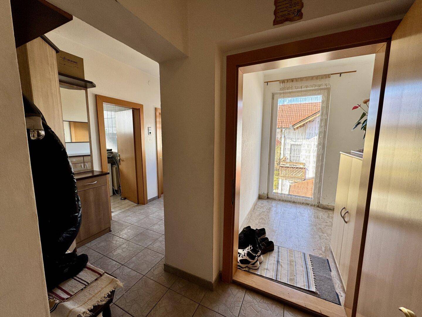 Eingangsbereich mit Fliesenboden und Zugang zu weiteren Räumen im Haus.