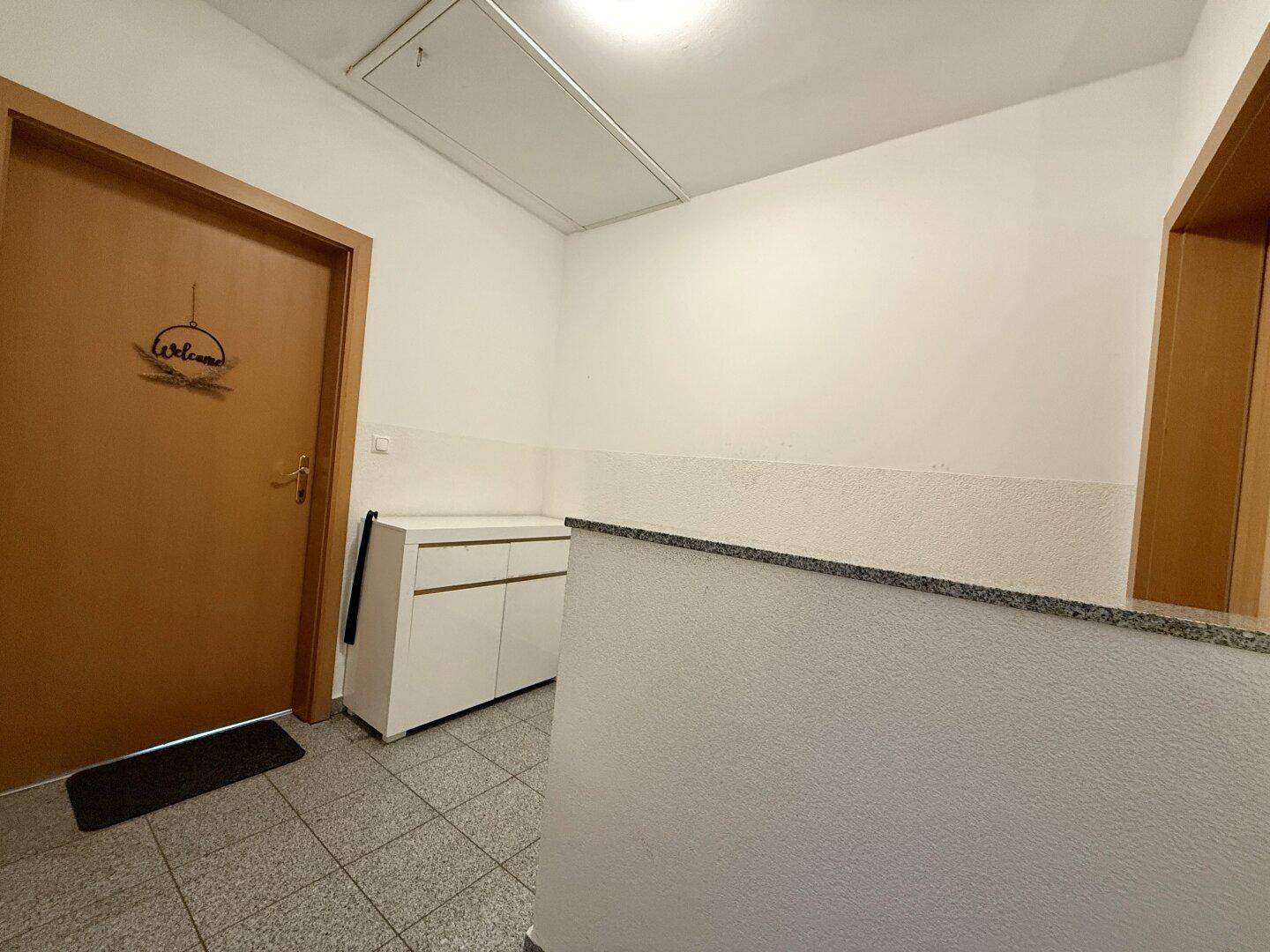 Eingangsbereich mit Fliesenboden und Treppenaufgang.
