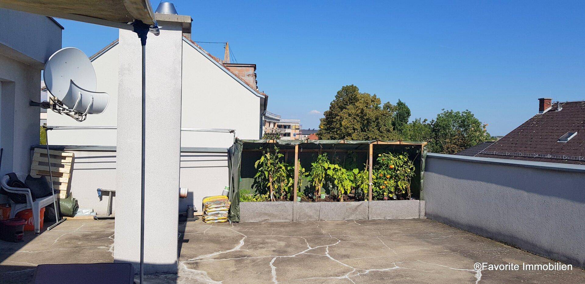 Geräumige Dachterrasse mit Hochbeeten für Pflanzen und einem weiten Blick über die Dächer.