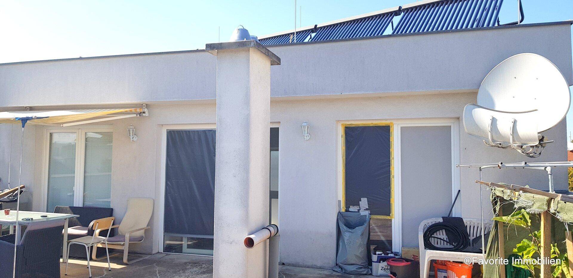 Dachterrasse mit Schiebetüren, Sonnenschutz und einem Satellitenempfänger, bereit für die Gestaltung.