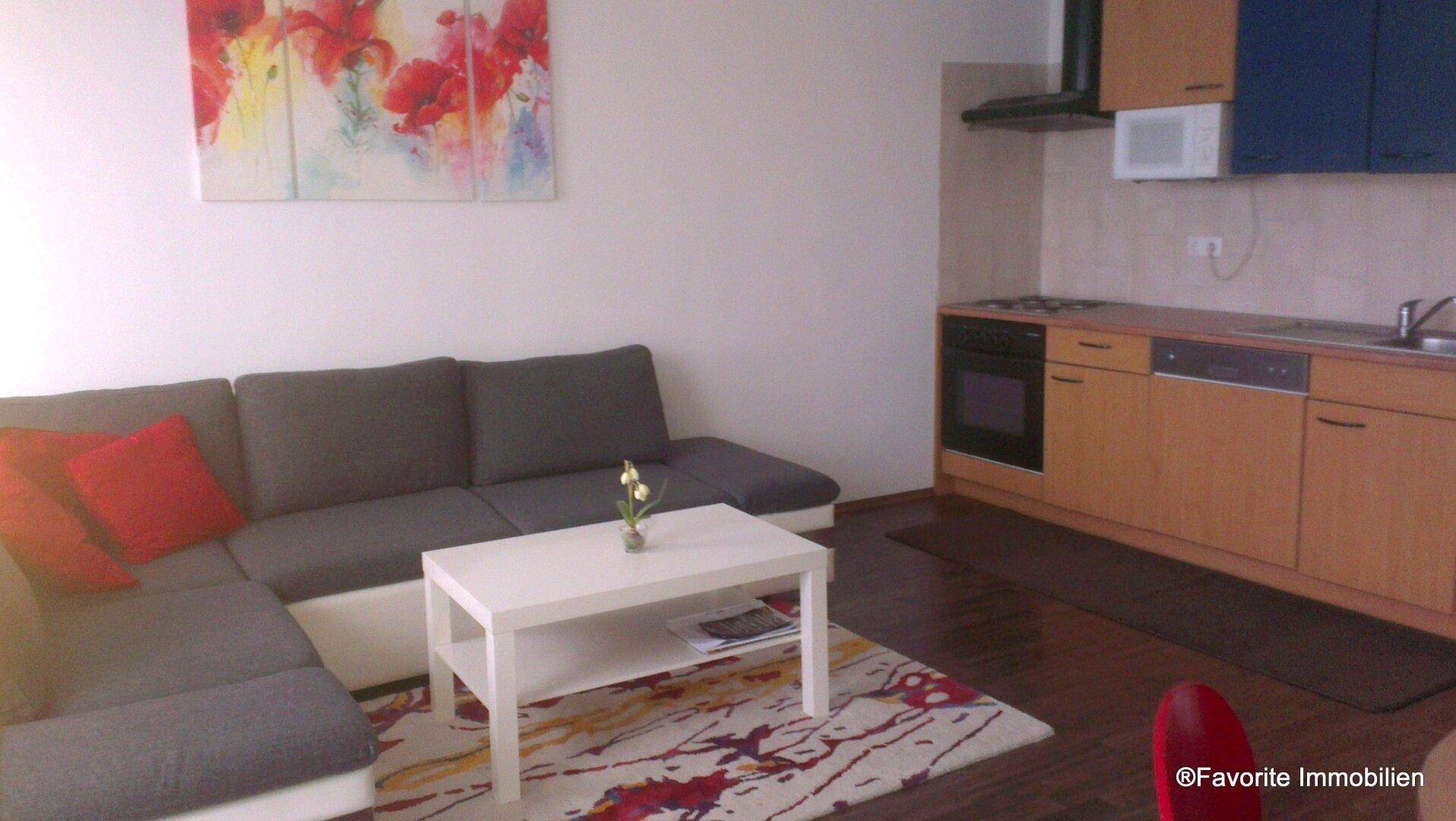 Wohnküche mit Holzelementen und einem bequemen Ecksofa, ideal für gesellige Abende.