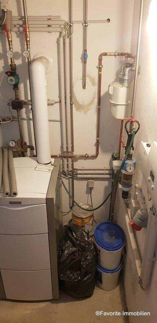 Detailansicht der Heizungsanlage mit Rohren, Ventilen und einem Warmwasserspeicher.