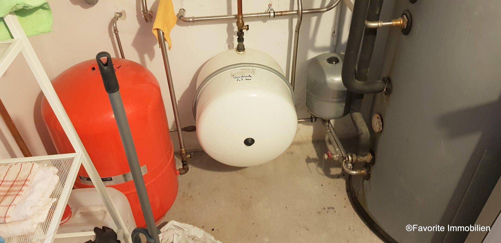 Technikraum mit verschiedenen Tanks und Installationen, die zur Gebäudetechnik gehören.
