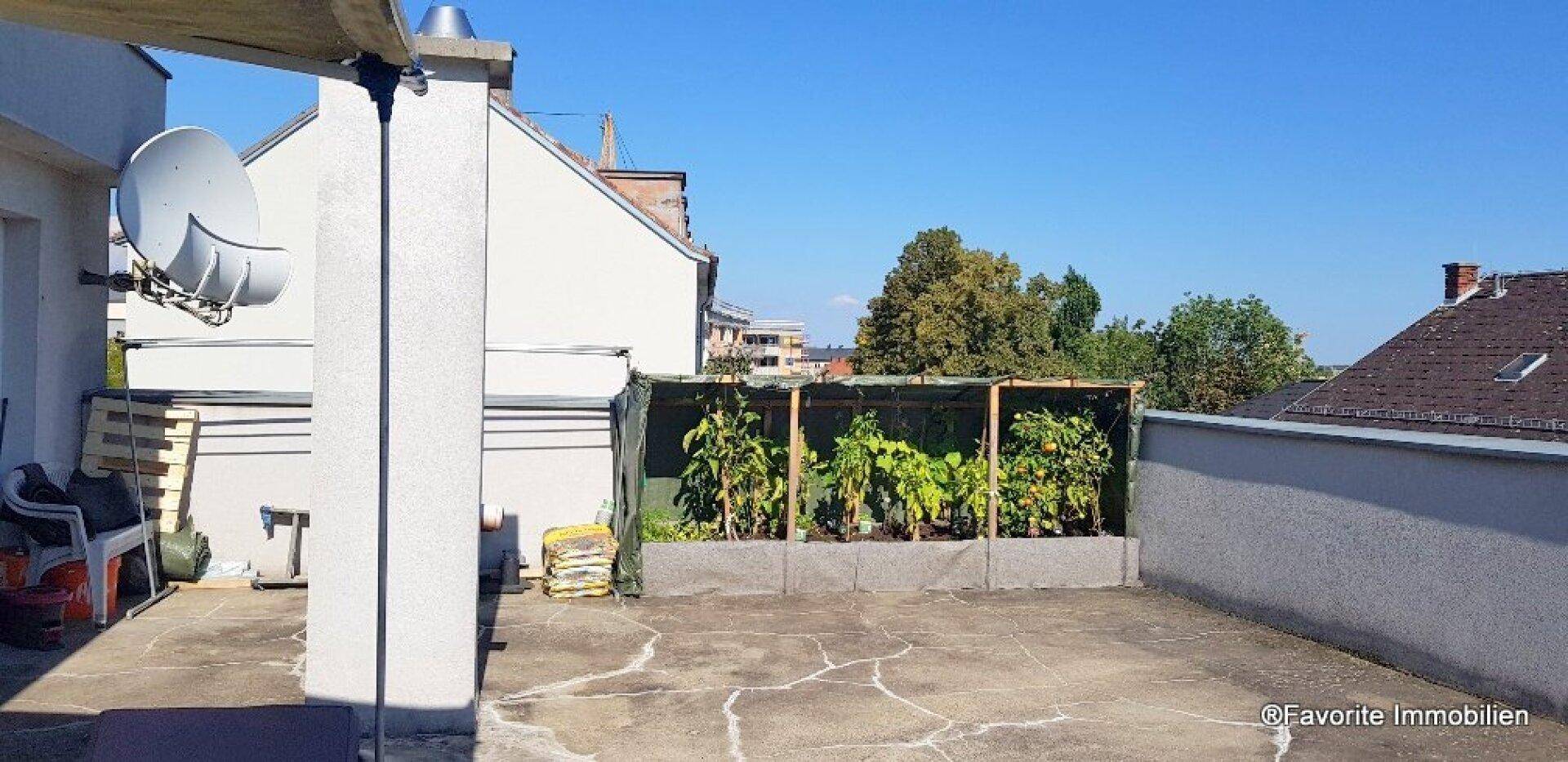 Geräumige Dachterrasse mit Hochbeeten für Pflanzen und einem weiten Blick über die Dächer.