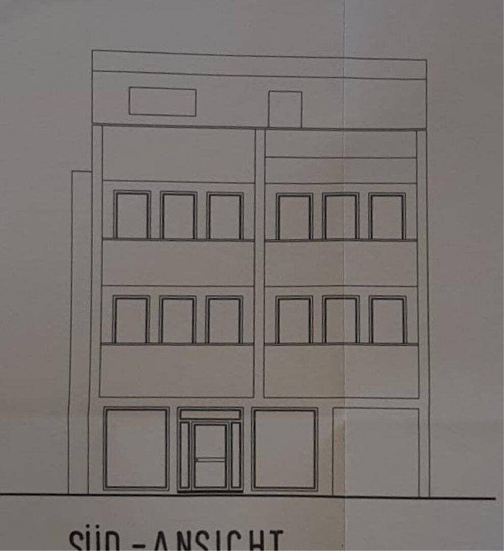 Südansicht des Gebäudes mit Fensteranordnung und Geschäftsfront im Erdgeschoss.