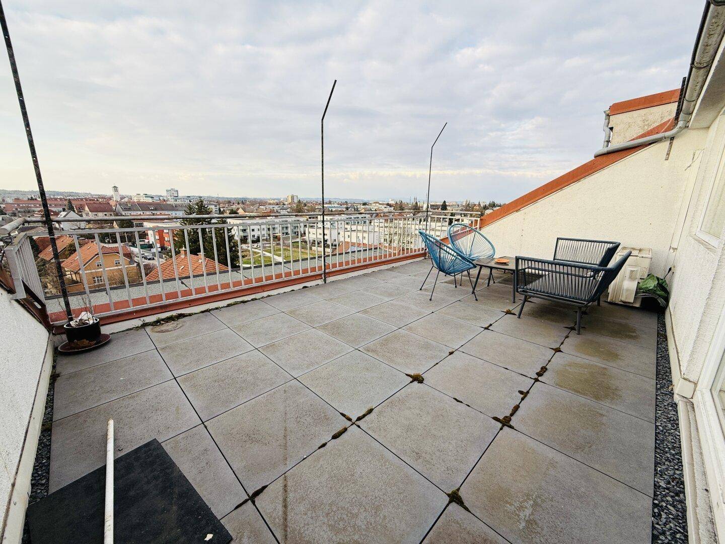 Weitläufige Dachterrasse mit Panoramablick über die Stadt und bequemen Outdoor-Möbeln.