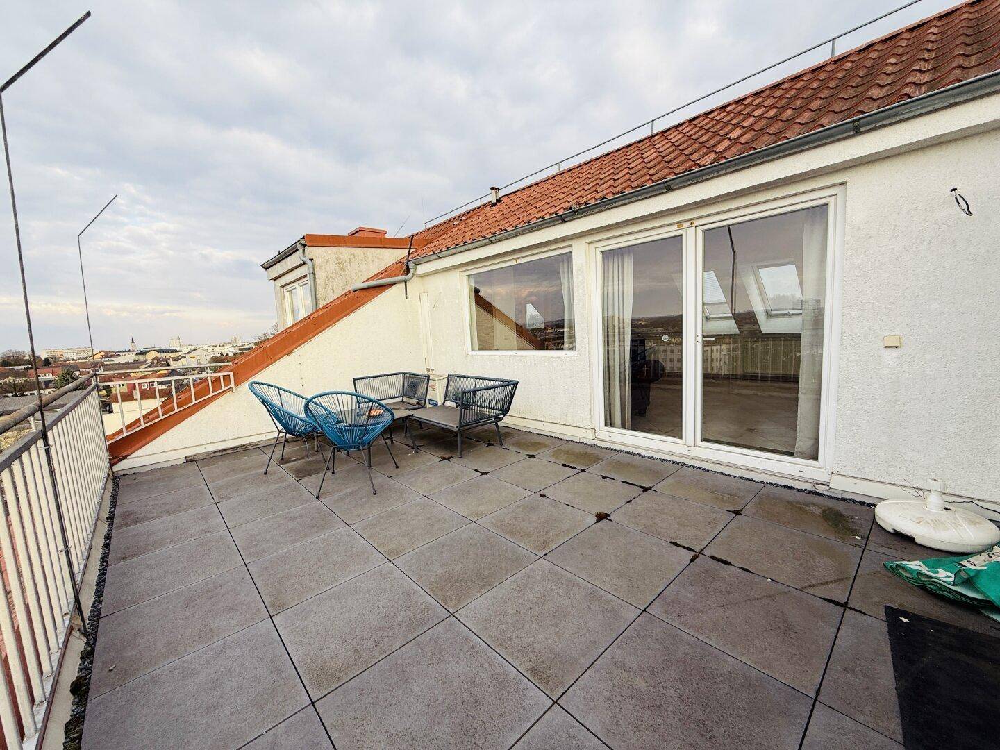 Geräumige Dachterrasse mit Stadtblick und Sitzgelegenheiten, ideal für Entspannung im Freien.