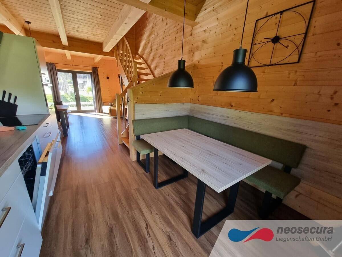 Moderner Küchenbereich mit integrierter Essbank und Holzboden, offen und einladend gestaltet.