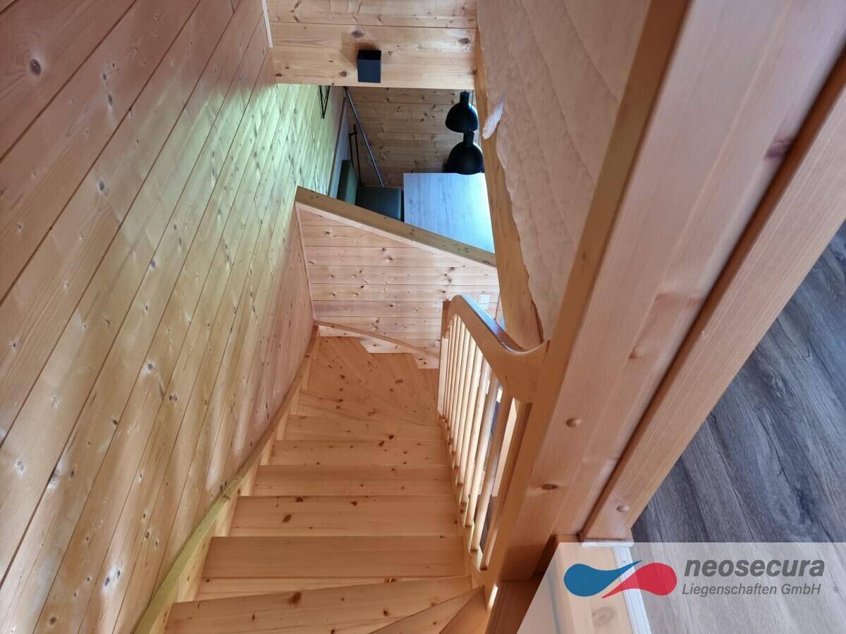 Helle Holztreppe, die die verschiedenen Ebenen des Hauses verbindet, mit natürlichem Lichteinfall.