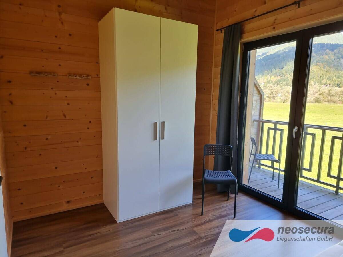 Helles Schlafzimmer mit Kleiderschrank und Balkonzugang, bietet einen schönen Blick auf die Landschaft.