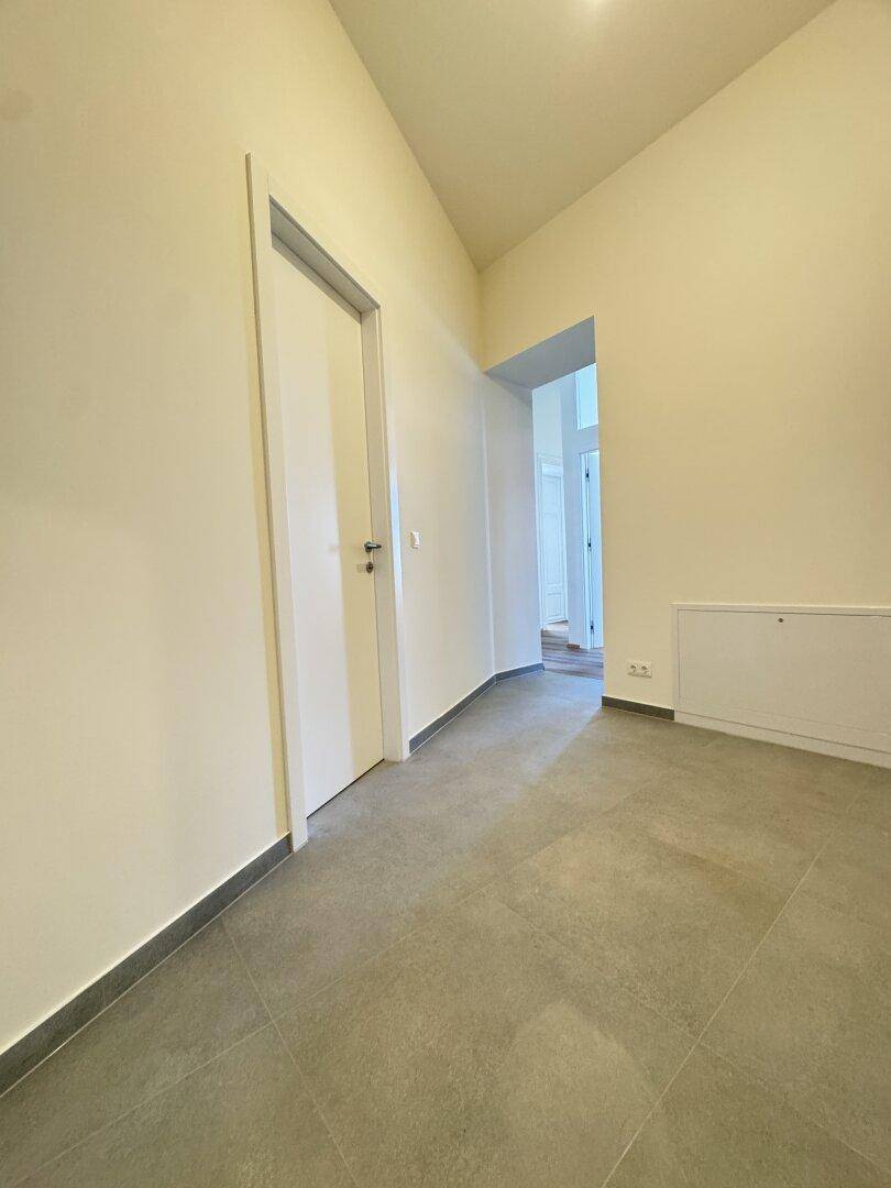 Heller Flur mit Fliesenboden und Zugang zu weiteren Räumen der Wohnung.