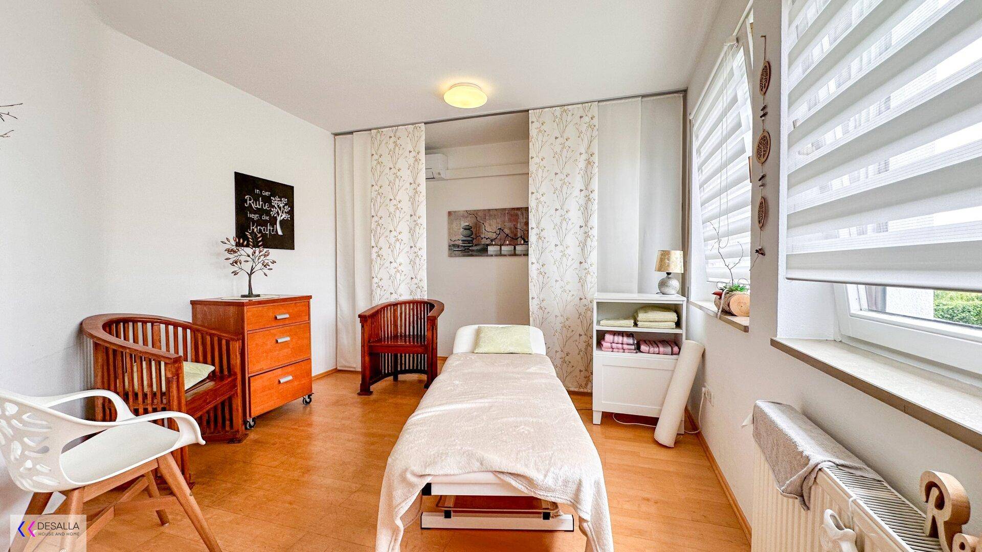 Helles Zimmer mit Liege und Holzmöbeln, ideal als Behandlungsraum oder Gästezimmer.