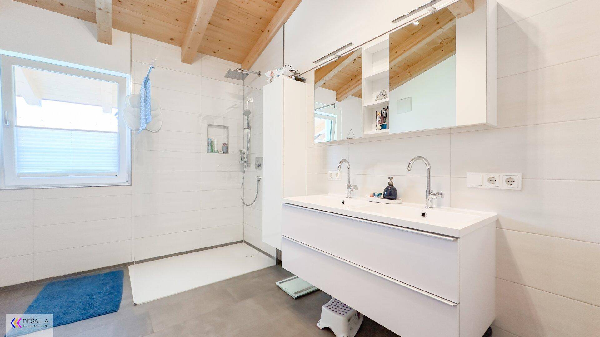 Modernes Badezimmer mit Doppelwaschbecken, großer begehbarer Dusche und Holzbalkendecke.