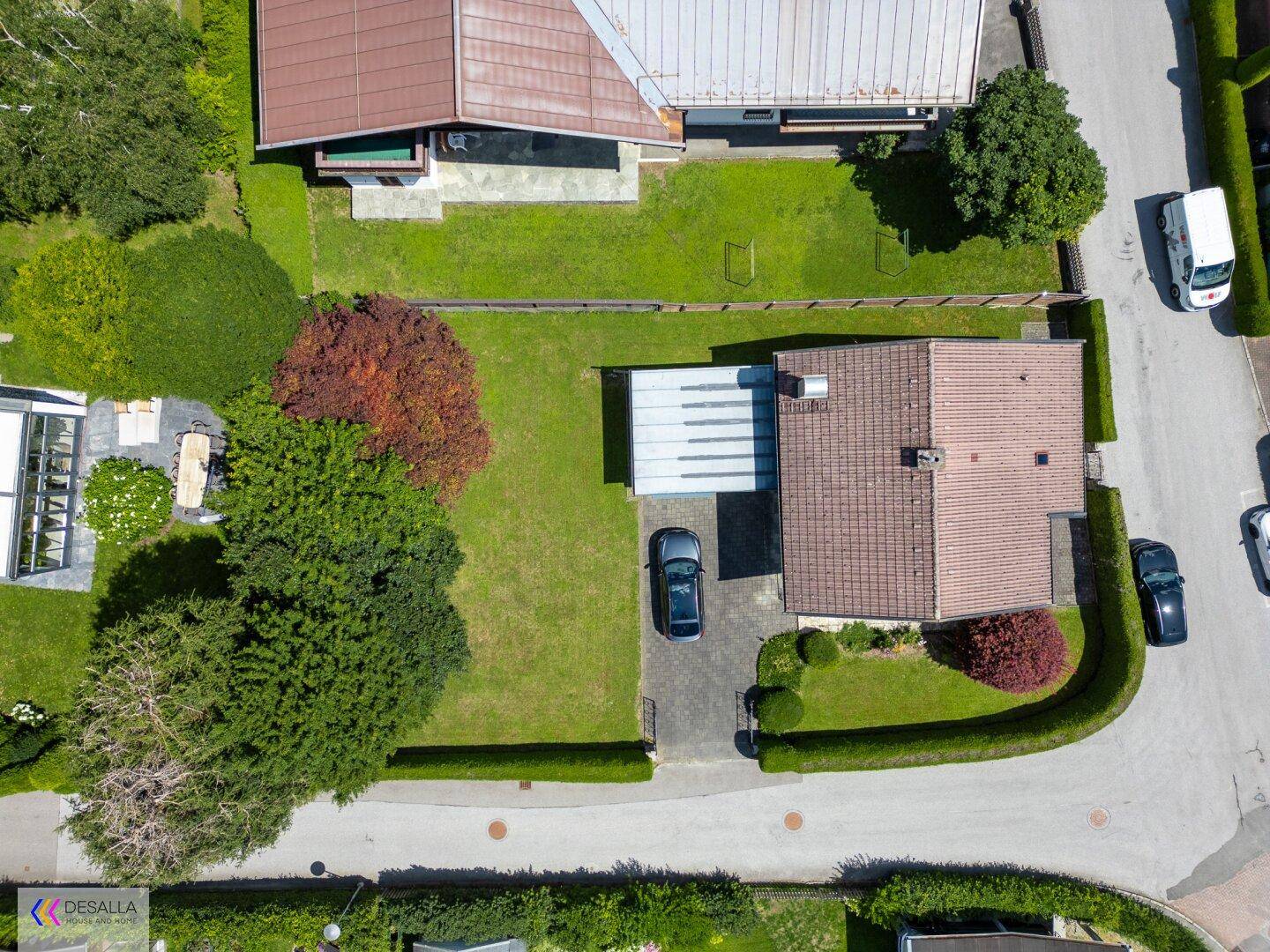 Draufsicht auf das Grundstück mit Haus, Garten, Auffahrt und einem Carport.
