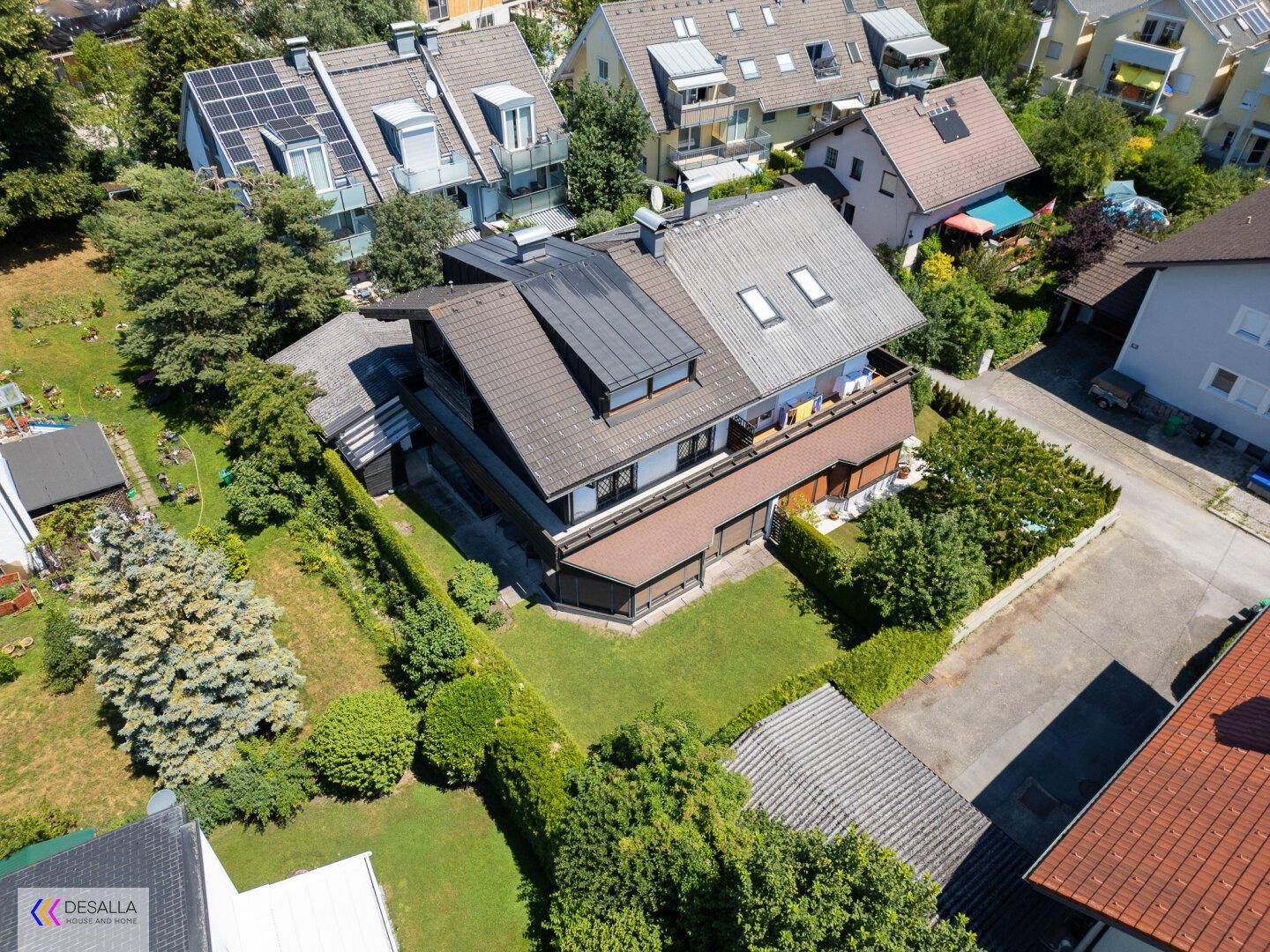 Vogelperspektive des Hauses mit gepflegtem Garten, umgeben von Hecken und Bäumen.