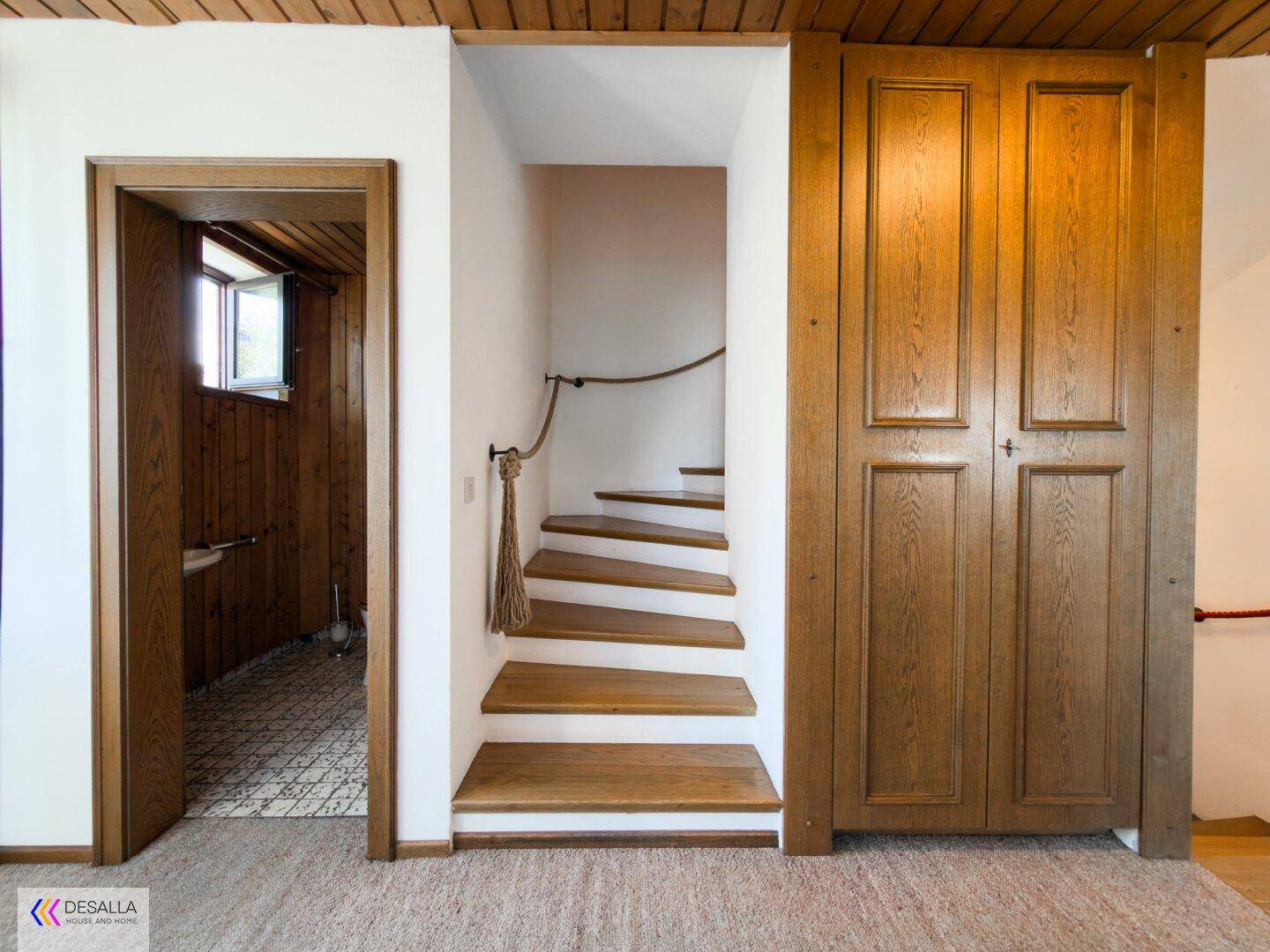 Flur mit Holztreppe, Einbauschränken und Zugang zu weiteren Räumen.