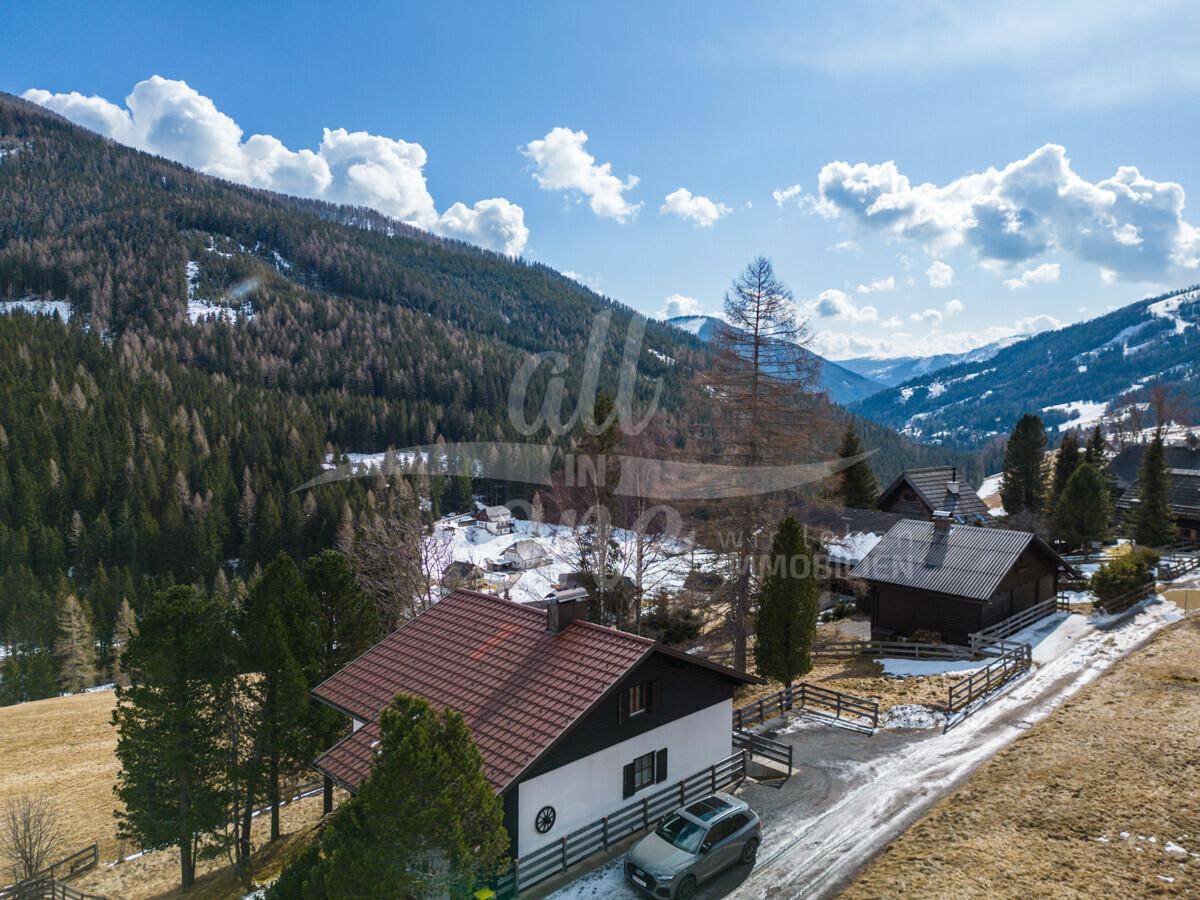 Panoramablick auf das Haus und die weite Berglandschaft unter blauem Himmel.