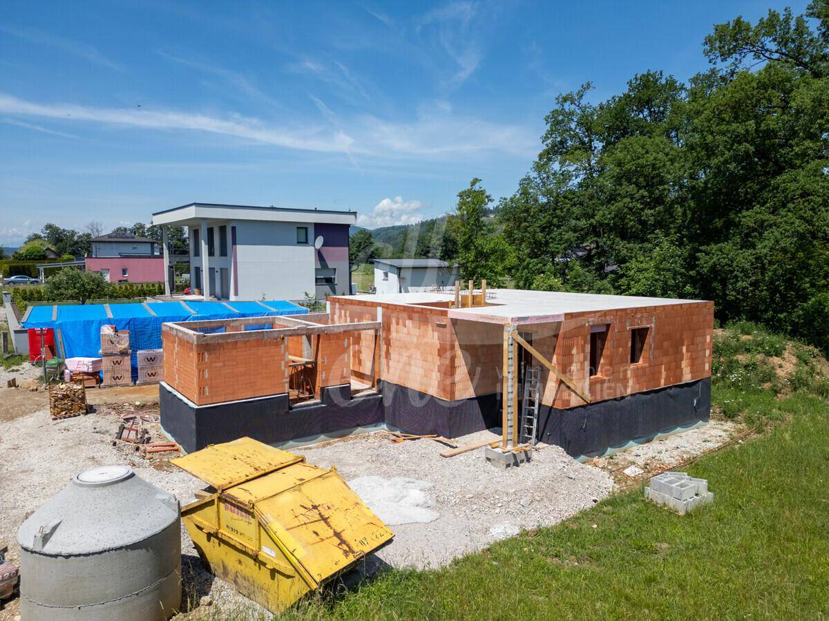 Rohbau eines modernen Einfamilienhauses mit Flachdach in sonniger Lage umgeben von Natur.