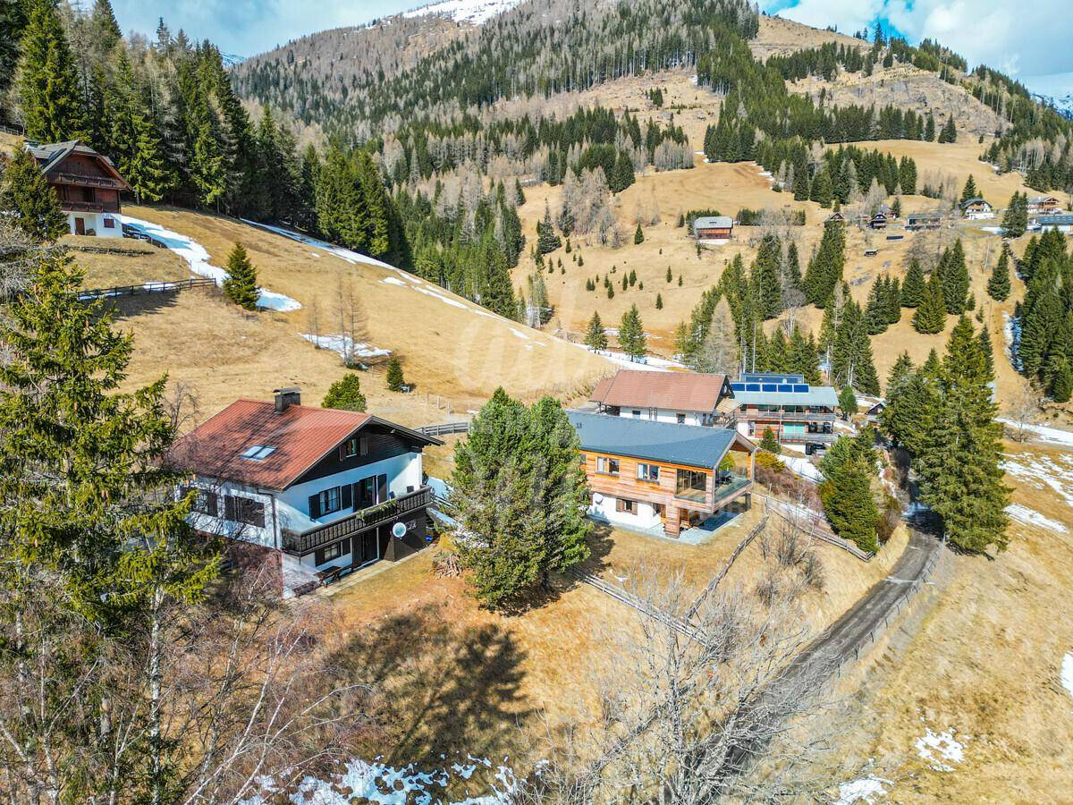 Panoramablick auf das Haus und die umliegende Berglandschaft mit teilweise schneebedeckten Hängen.