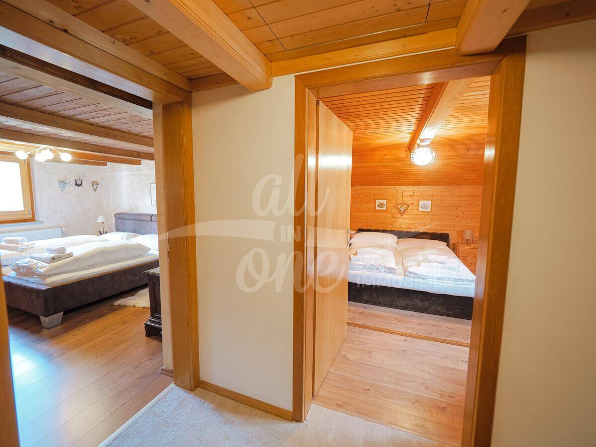 Flur im Obergeschoss mit Holzboden und Zugang zu mehreren Schlafzimmern.