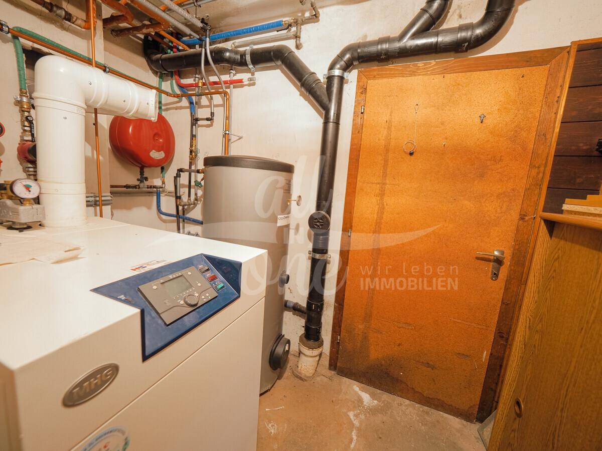Heizungsraum mit moderner Heizungsanlage und Warmwasserspeicher.