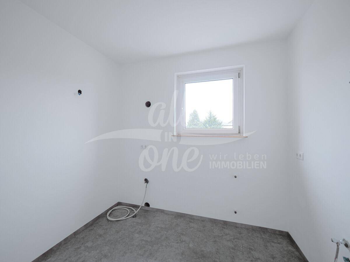 Unfertige Küche mit Anschlüssen für Geräte und einem Fenster.