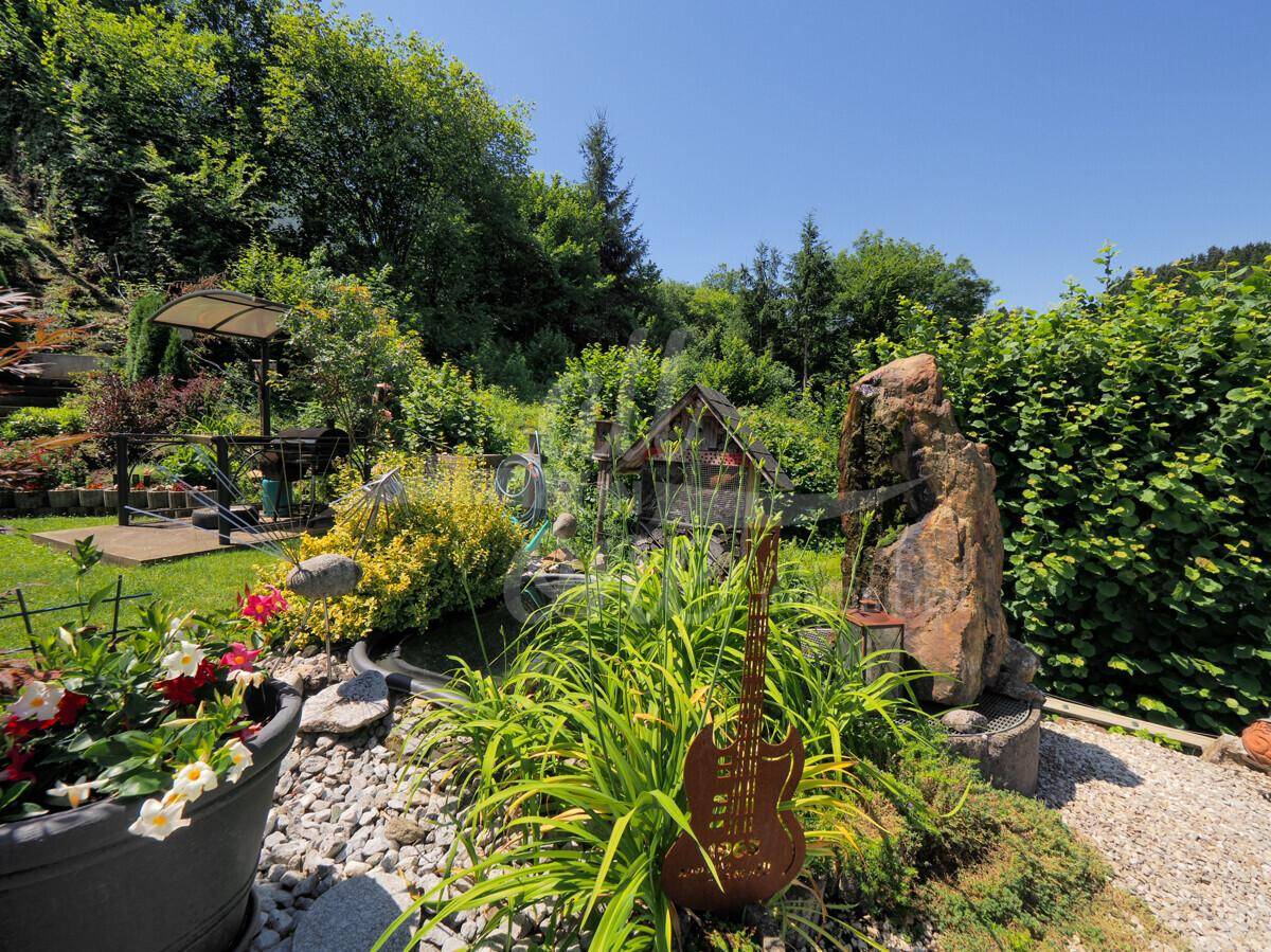 Kreativ gestalteter Gartenbereich mit Kieswegen, Pflanzen und dekorativen Elementen.