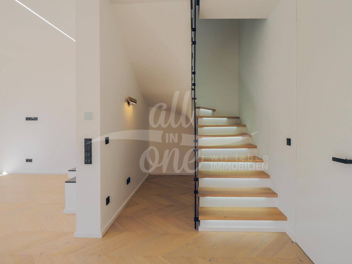 Elegante Holztreppe mit indirekter Beleuchtung und modernem Design im Flur.