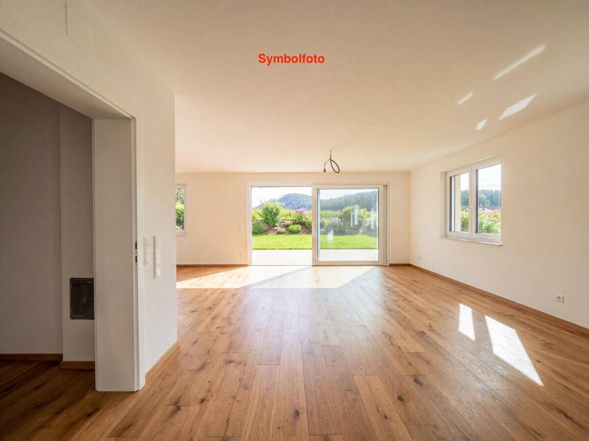 Helles Wohnzimmer mit hochwertigem Holzboden und großen Schiebetüren zum Garten.