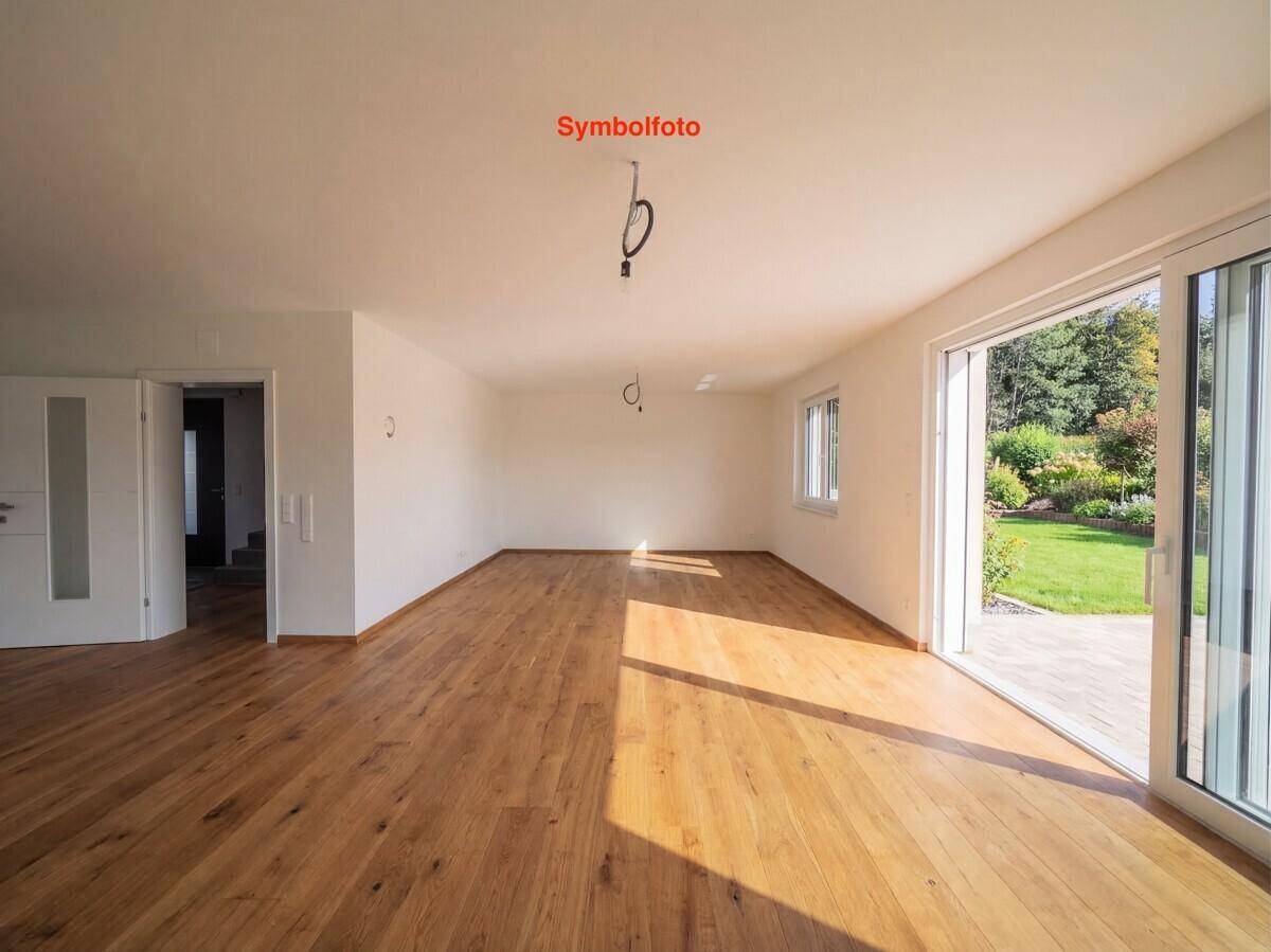 Geräumiges Wohnzimmer mit Holzboden und Zugang zu weiteren Räumen, bereit zur individuellen Gestaltung.