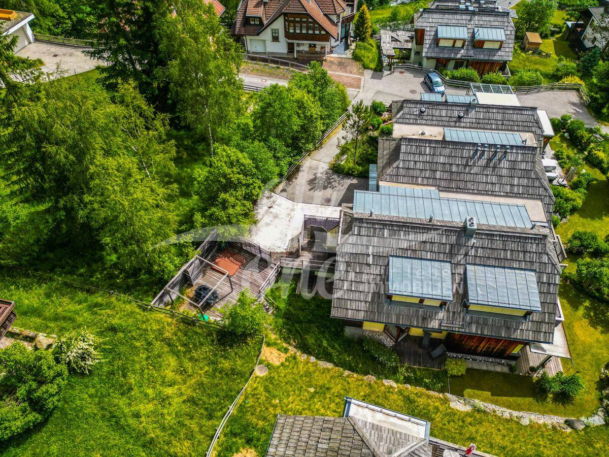 Luftaufnahme des Anwesens mit mehreren Gebäuden, grünen Rasenflächen und einem Whirlpoolbereich.