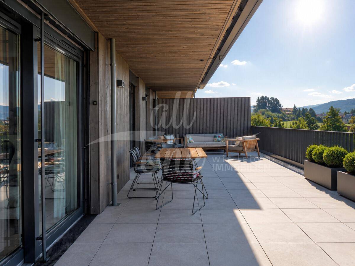 Große Terrasse mit Holzverkleidung, Fliesenboden und verschiedenen Sitzbereichen für Entspannung.