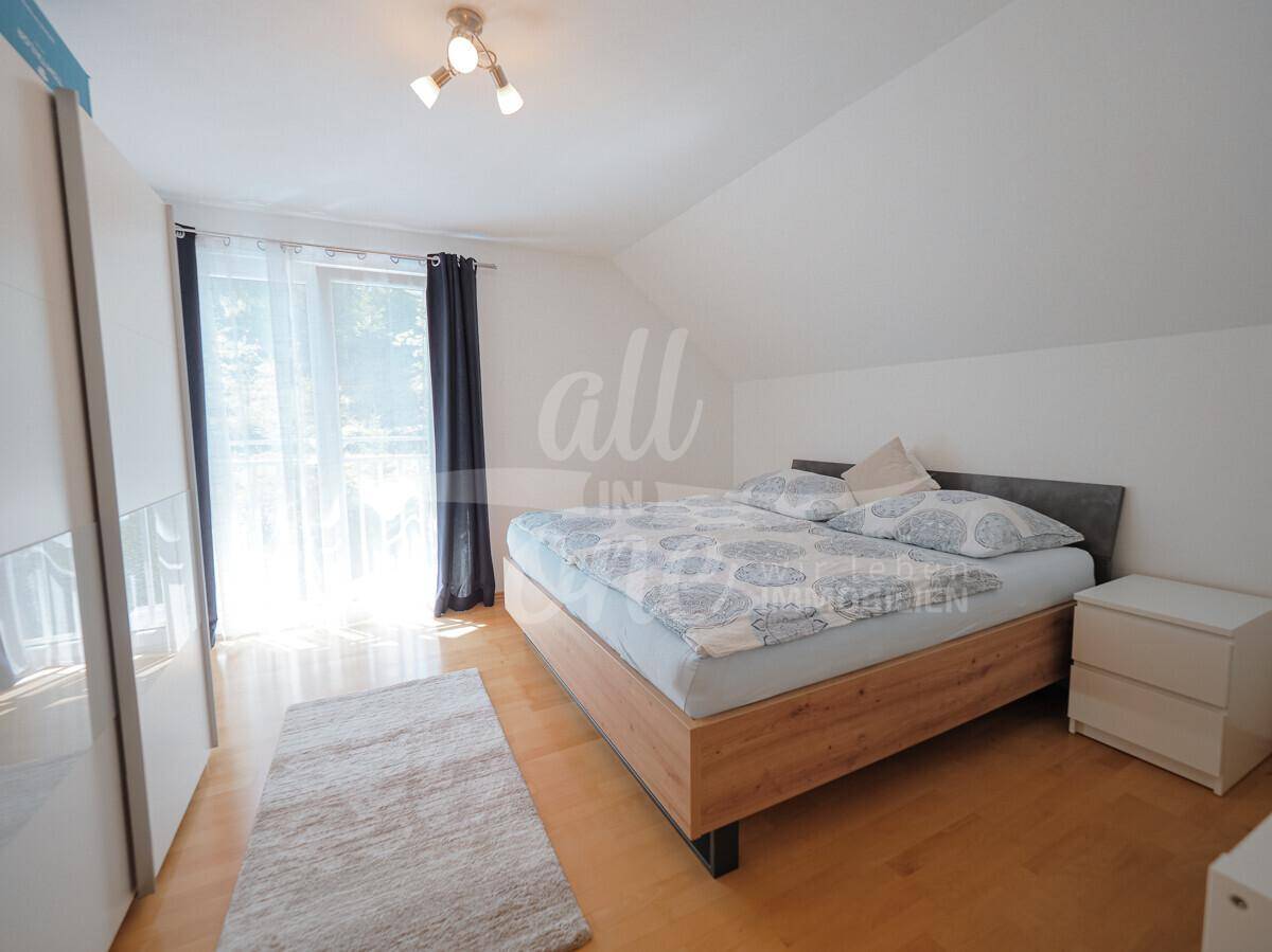 Gemütliches Schlafzimmer mit Holzboden, großem Bett und Kleiderschrank.