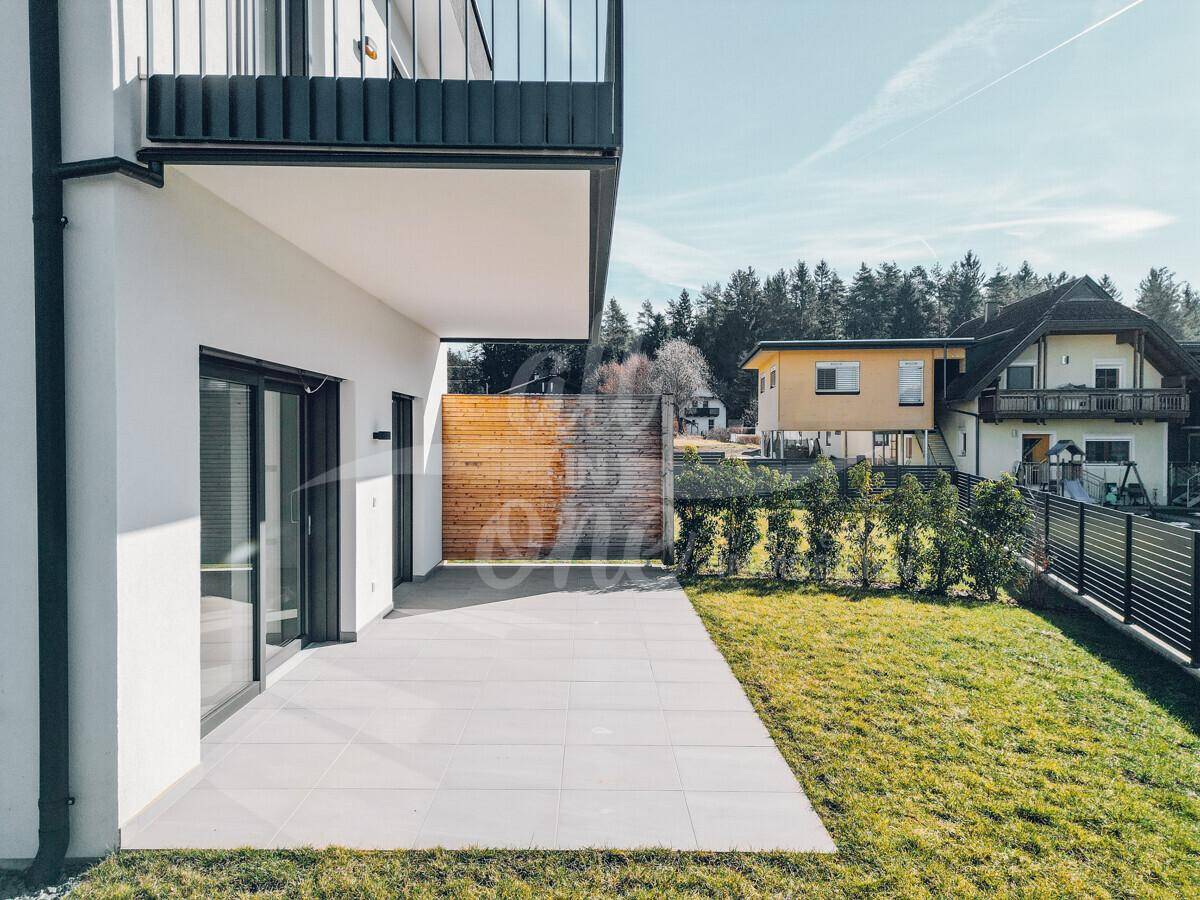 Großzügige Terrasse mit direktem Zugang zum Garten und moderner Holzverkleidung.