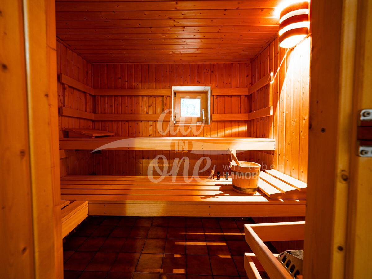 Traditionelle Holzsauna mit mehreren Bänken und einem kleinen Fenster.