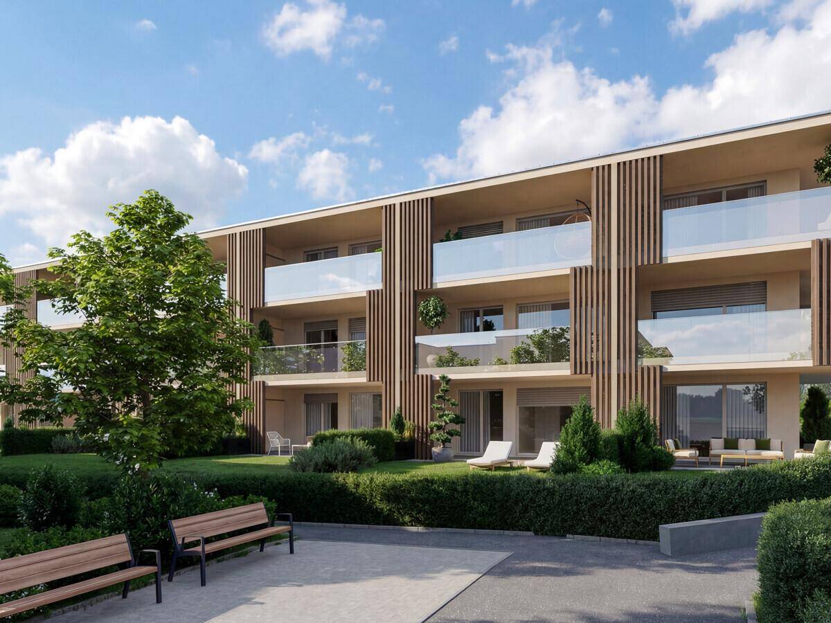 Moderne Wohnanlage mit Balkonen, Terrassen und gepflegten Grünflächen mit Sitzbänken.