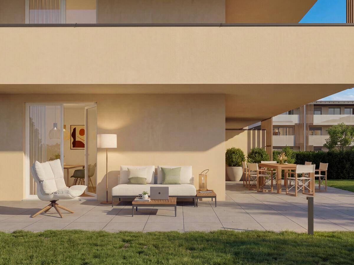 Großzügige Terrasse mit Sitzgelegenheiten und Rasenfläche, ideal für Entspannung im Freien.