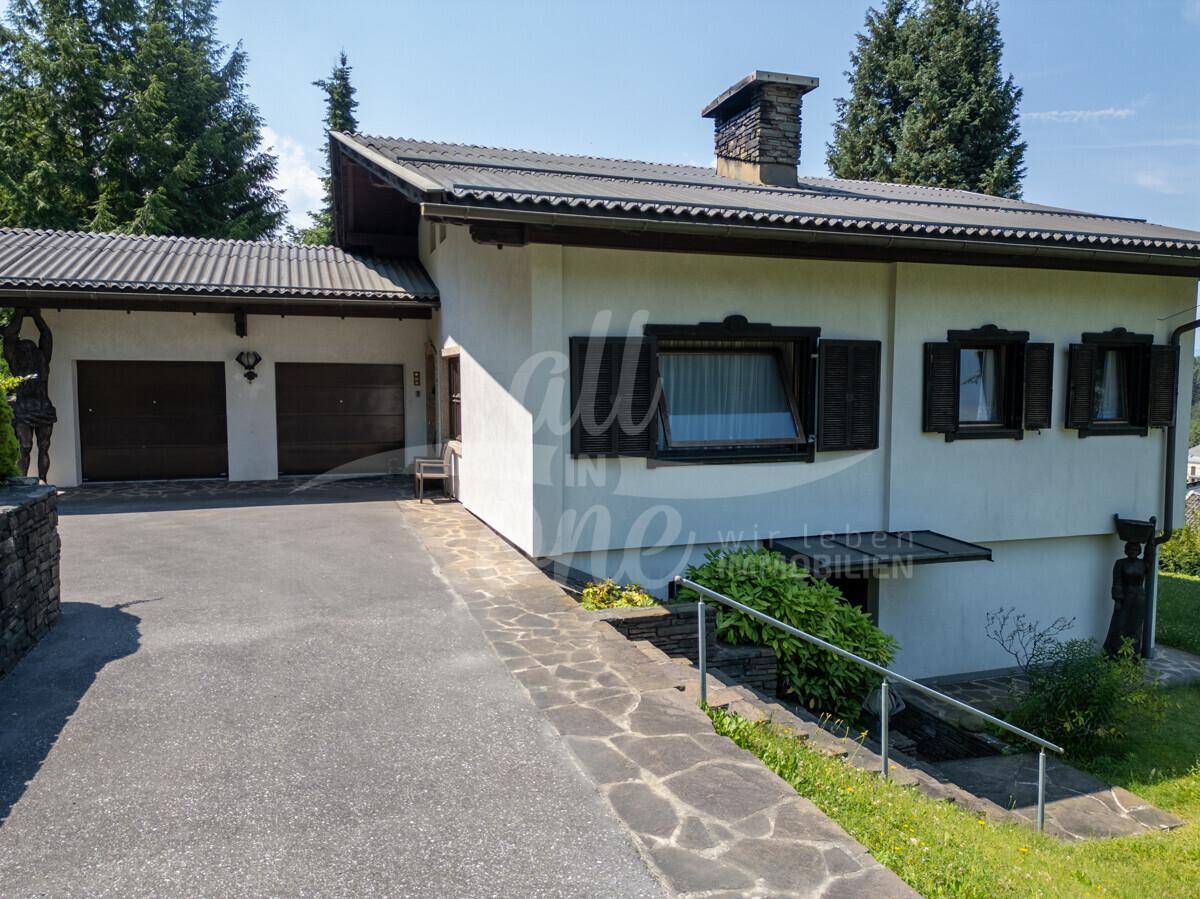 Vorderansicht des Hauses mit Zufahrt, Treppe zum Eingang und traditionellen Fensterläden.