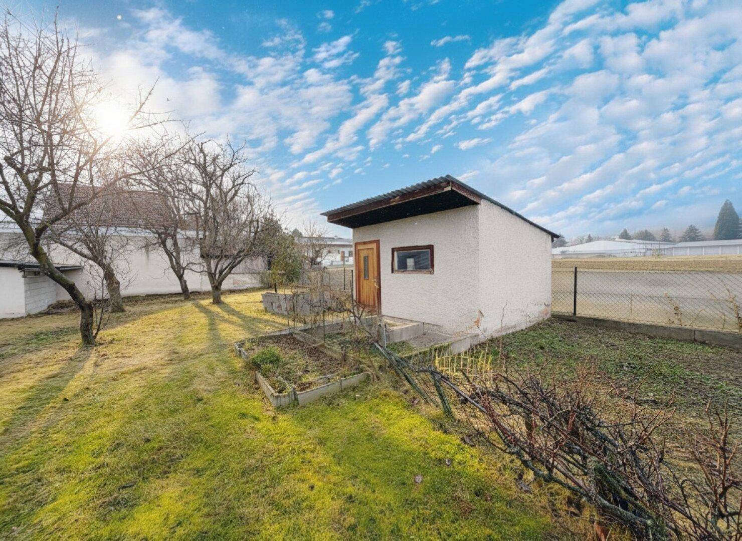 Geräumiger Garten mit Gartenhaus und Obstbäumen, ideal für Hobbygärtner.