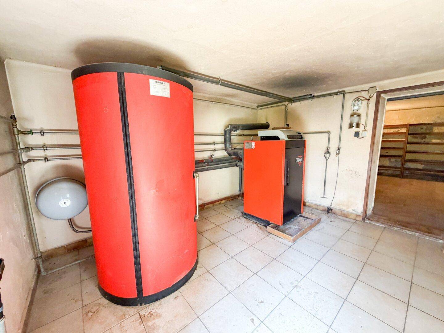Heizungsraum mit Warmwasserspeicher und Heizungsanlage, die eine effiziente Wärmeversorgung gewährleistet.