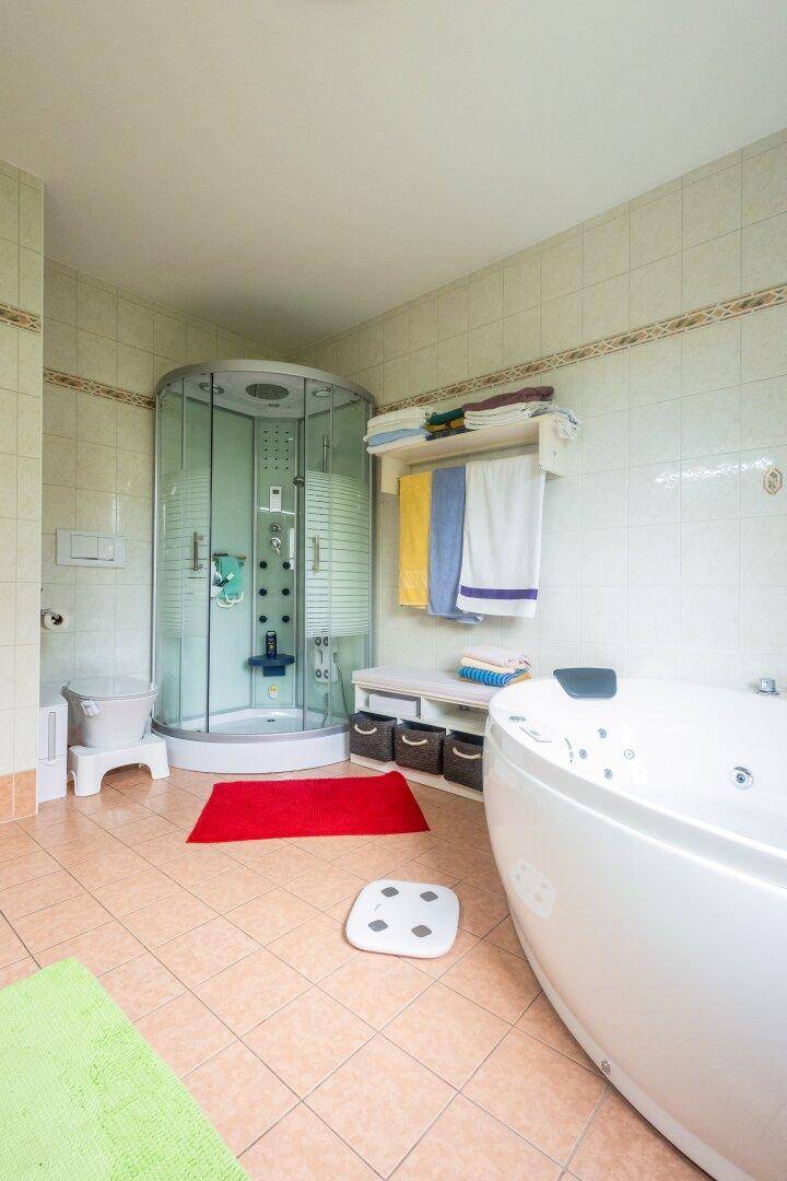 Geräumiges Badezimmer mit Eck-Whirlpool, Duschkabine und hellen Fliesen.