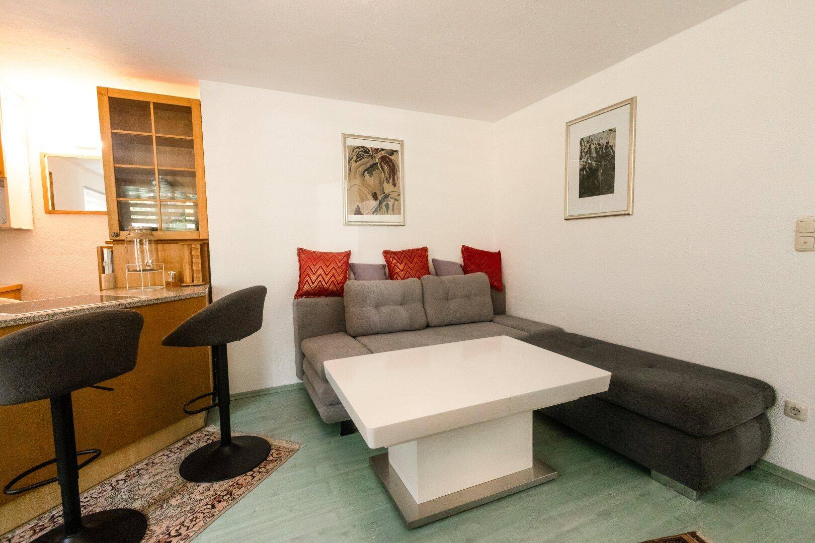 Wohnbereich mit Ecksofa, Couchtisch und Blick auf die Küchenzeile.