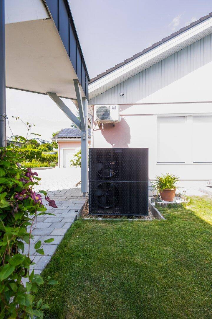 Außenansicht des Hauses mit installierter Wärmepumpe und Klimaanlage.
