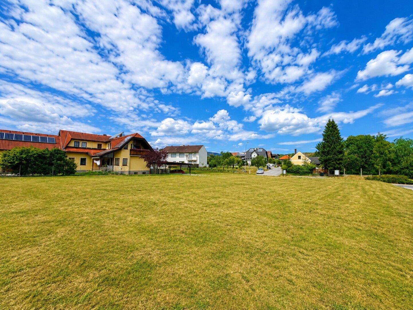 Offenes Grundstück mit weitem Blick auf die Nachbarschaft und die grüne Umgebung.