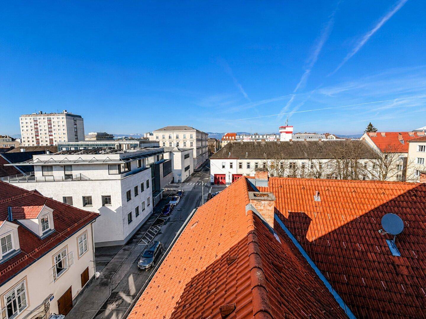 Weitblick über die städtische Umgebung mit verschiedenen Gebäudetypen und Dächern.