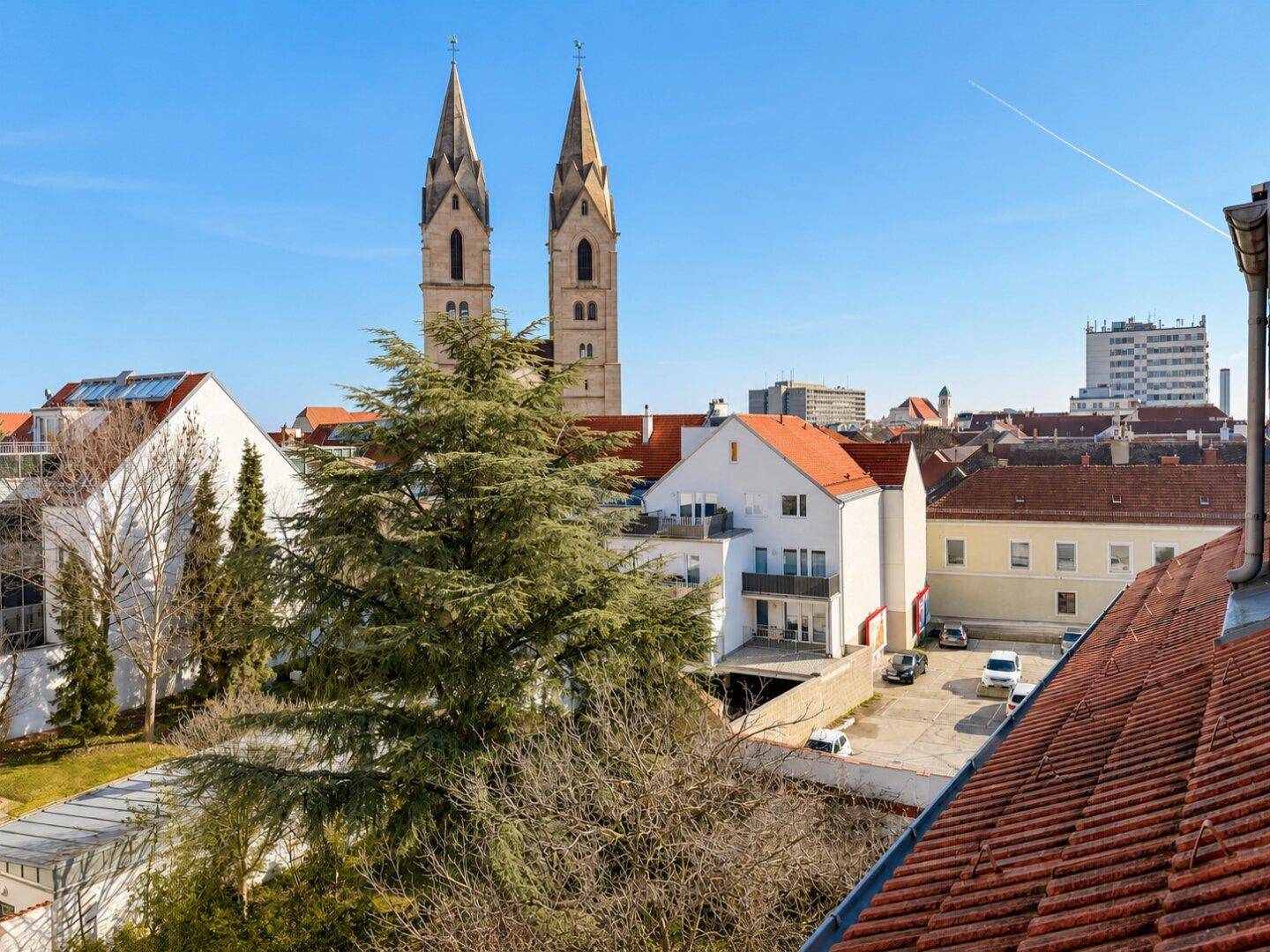 Panoramablick über die Stadt mit historischen Kirchtürmen und umliegenden Dächern.