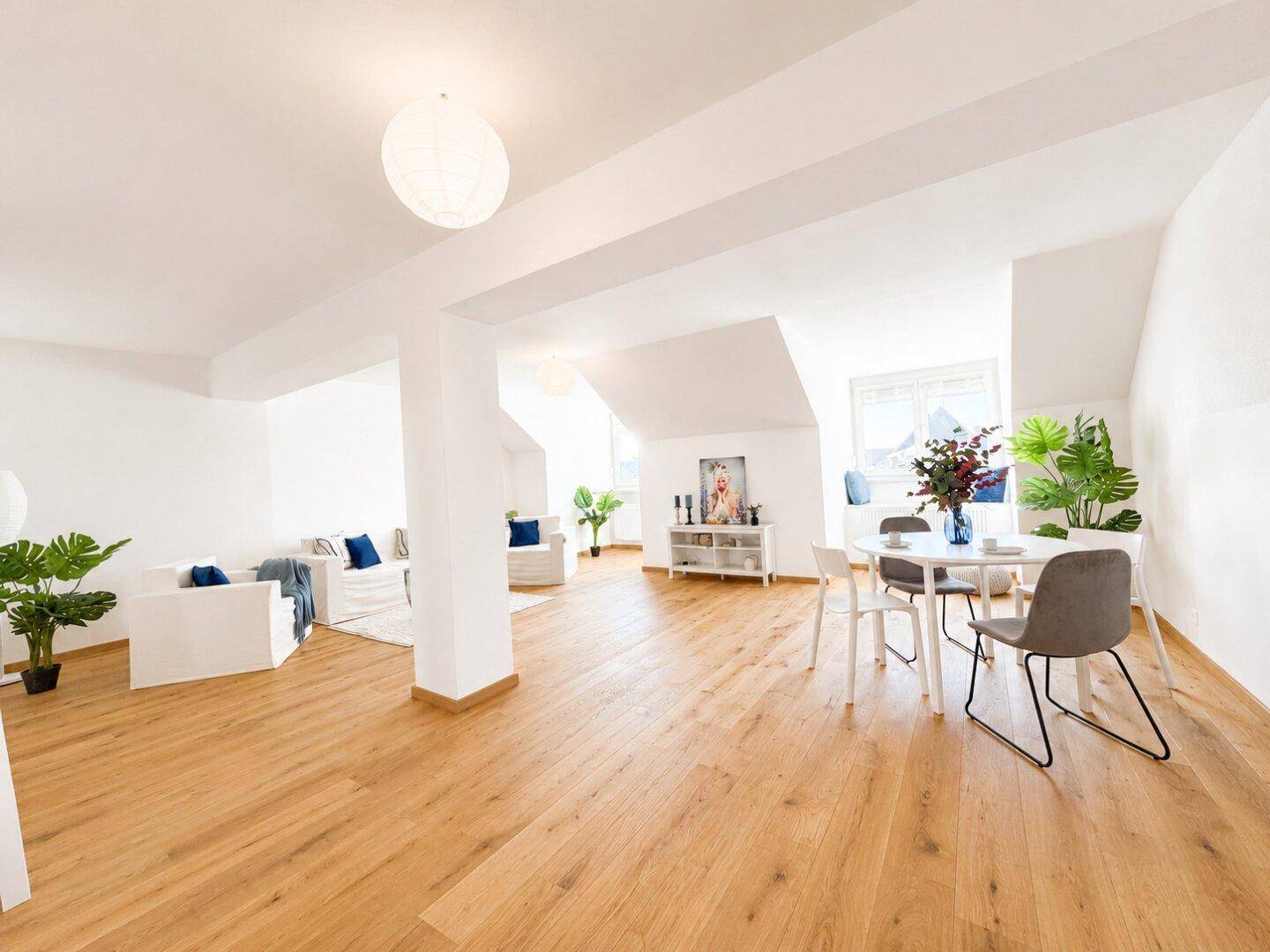 Geräumiger Wohn-Essbereich mit Holzboden, viel Tageslicht und moderner Ästhetik.