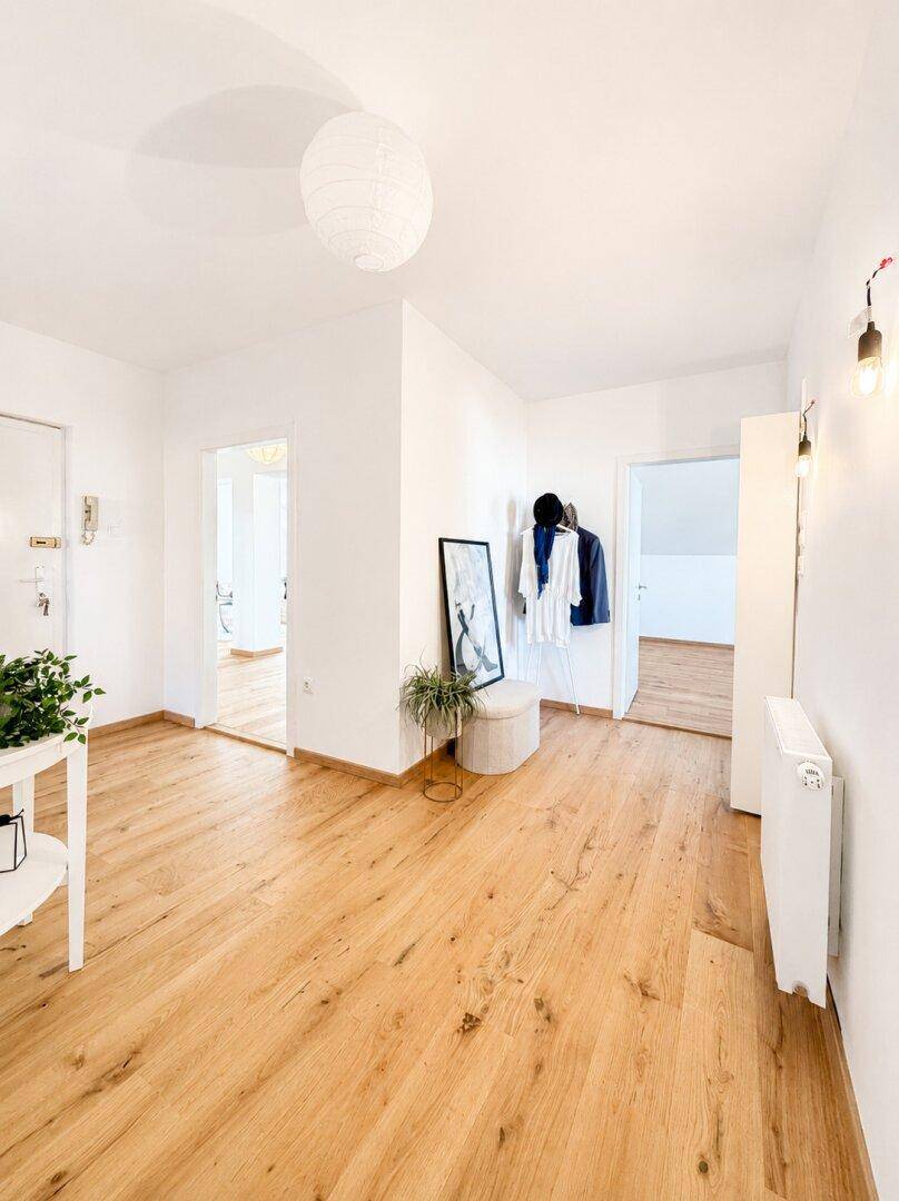 Geräumiger Flur mit Holzboden, Garderobe und hellem Ambiente.